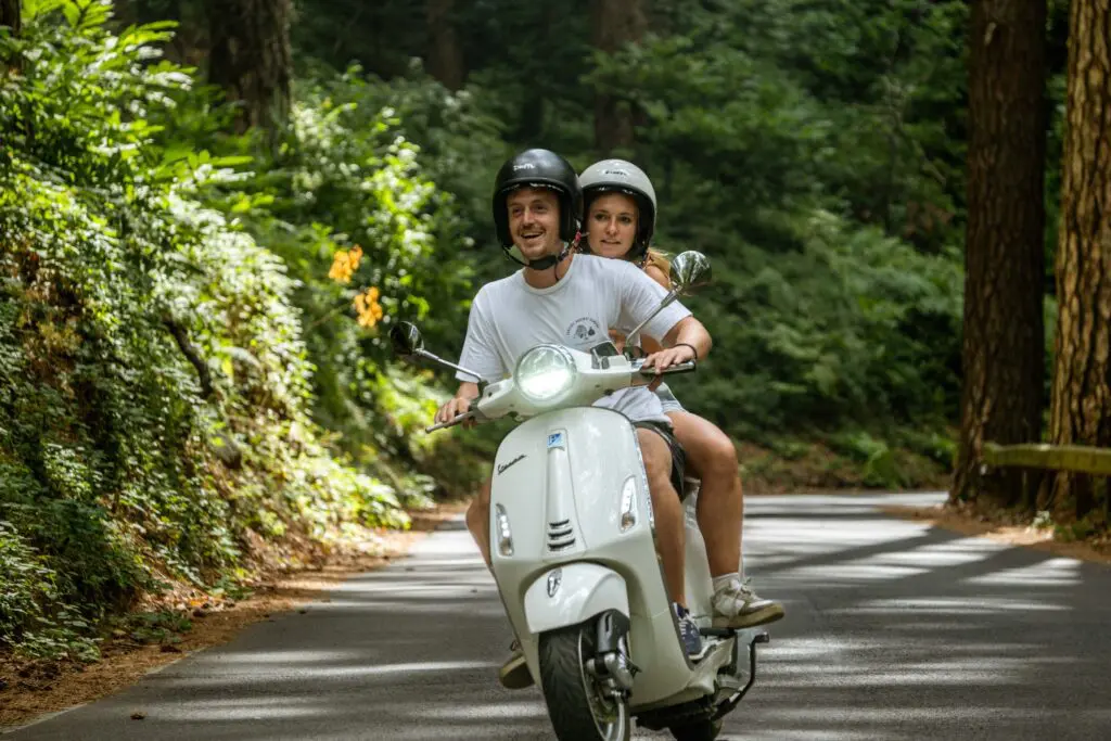 couple driving a Vespa in Amalfi during Vespa trip Koppel dat Vespa rijdt in Amalfi tijdens Vespa trip