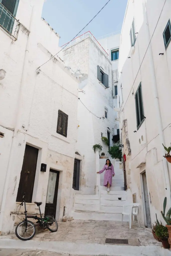 woman walking on steps in ostuni white city