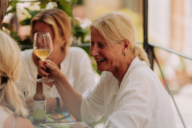 Woman laughing and drinking wine on The Vespa Trip in Tuscany